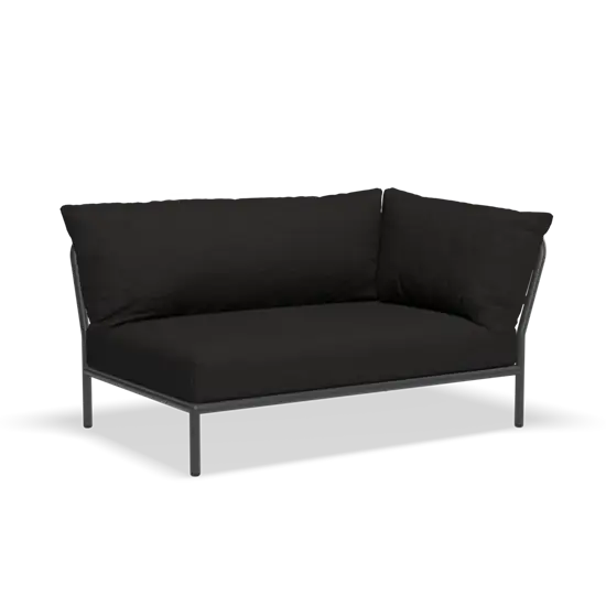 Mørk hjørnesofa med slankt metalstel og polstrede puder, minimalistisk design.