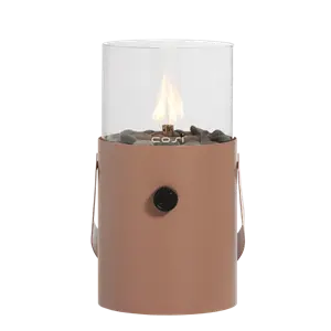 Cylindrisk gaslanterne i jordfarve med glas top, flamme, sort knap og dekorative sten.