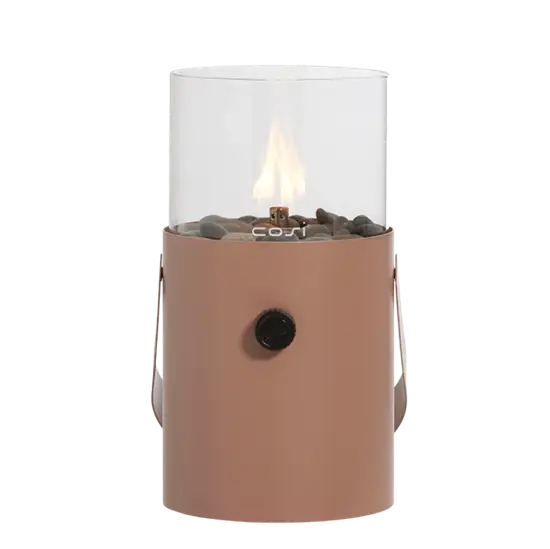 Cylindrisk gaslanterne i jordfarve med glas top, flamme, sort knap og dekorative sten.