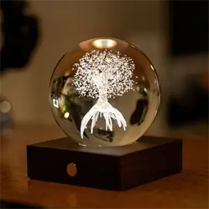 Sfærisk lampe med 3D-trædesign, udsender varmt lys, placeret på en kvadratisk base.