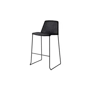 Sort barstol med flettet sæde og ryglæn, slanke ben og moderne, minimalistisk design.