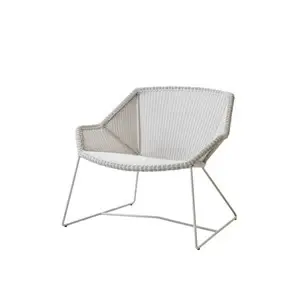 Hvid lounge stol med flettet sæde og ryglæn, støttet af vinklede metalben. Åbne sider giver et moderne look.