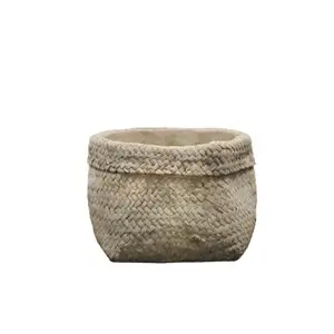 Rund cementpotte med flettet mønster og rustik finish, med kant øverst. Diameter 17 cm.