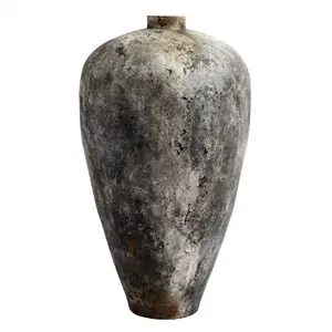 Høj, slank krukke med smal åbning, rustgrå nuancer og tekstureret overflade i terracotta.