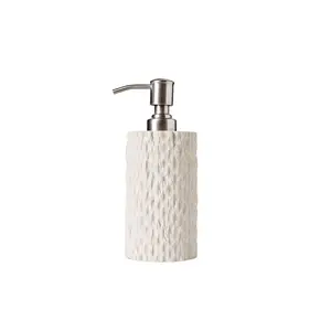 Sæbedispenser fra Muubs Kama med cylinderform, tekstureret overflade og metalpumpe.