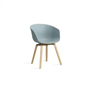 Spisebordsstol med buet, blå sæde og lyse træben. Moderne og minimalistisk design.