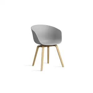 Grå stol med buet ryglæn og fire træben i moderne design.