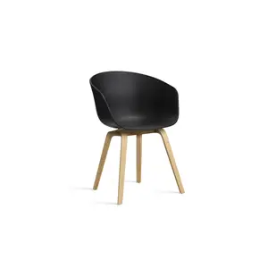 Sort spisebordsstol med rund ryg og sæde, fire skrå træben. Designet er moderne og minimalistisk.