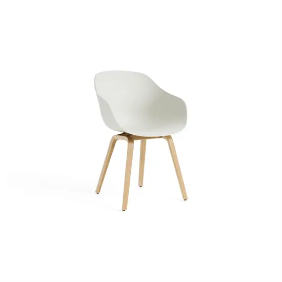 Minimalistisk stol med buet sæde, lave armlæn og lyse ben. Enkel og funktionel design.