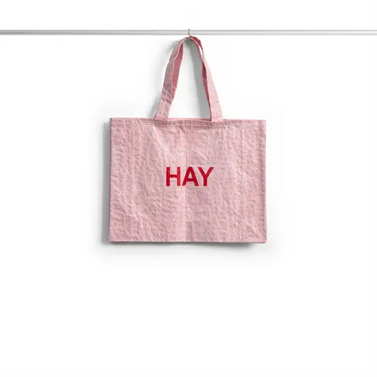 Lys pink indkøbstaske med røde "HAY" bogstaver i midten.