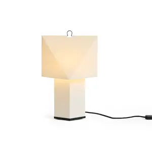 Geometrisk bordlampe i hvid med sorte accenter og synlig sort ledning.