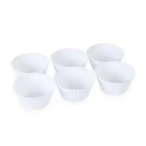 Seks hvide silikone muffinforme i to rækker på en neutral baggrund.