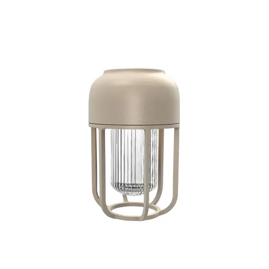 Beige udendørslampe, cylindrisk form, ribbet glas i midten, omgivet af en ramme.