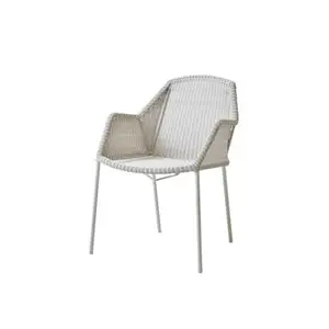 Hvid stol i flettet design med armlæn og slanke ben, velegnet til udendørs brug.