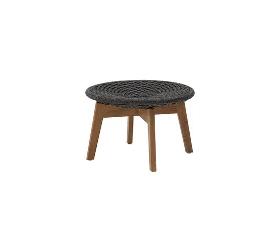 Rund fodskammel/sidebord i mørkegrå flet med teakben, enkel og velegnet til udendørs brug.