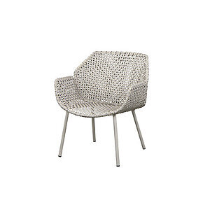 Loungestol med åben flet i sandfarver og fire cylindriske ben.