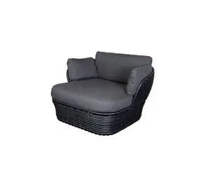 Komfortabel loungestol med flettet design, grå hynder og høj ryg for ekstra støtte.