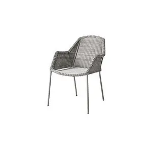 Stol med vævet design, armstøtter og slanke ben i en neutral farve.