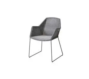 Udendørs stol med flettet ryg og sæde, integrerede armlæn og minimalistiske metalben.