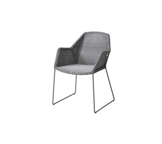 Udendørs stol med flettet ryg og sæde, integrerede armlæn og minimalistiske metalben.