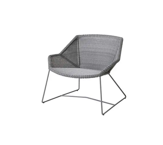 Lys grå loungestol med flettet mønster og metalben. Åben design og bred siddeflade.