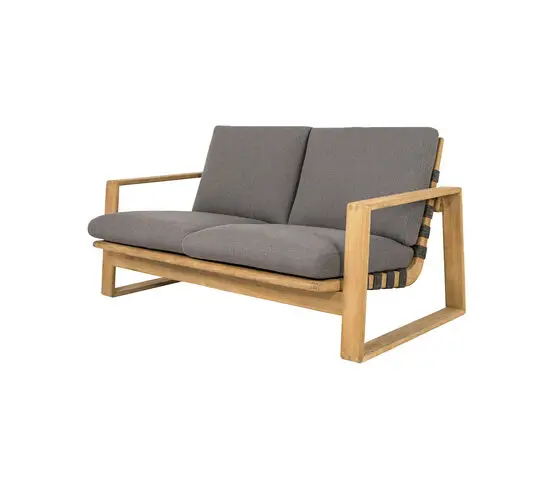 Sofa med lys træramme, mørkegrå puder og flettede detaljer på sider og bagside.