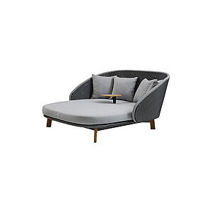 Udendørs daybed med grå vævede sider, lysegrå hynder, tre puder og et lille bord i midten.