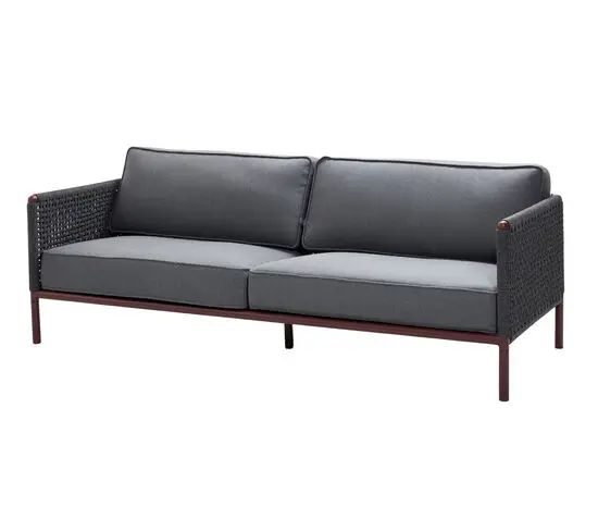 Moderne 3-pers. sofa med mørkegrå hynder, flettet arm- og rygstøtte, bordeaux ramme.