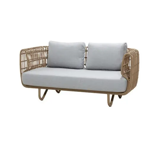 To-sædet sofa med lys grå hynder, vævet base i naturfarve, afrundede armlæn, minimalistisk design.