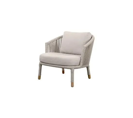 Loungestol med flettet rebdesign, neutrale hynder og afrundede armlæn.