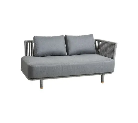Grå sofa med vævet design og hynder, står på fire ben. Modern og enkel stil.