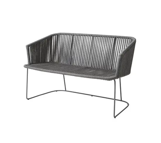 Grå bænk med minimalistisk design, vævet sæde og ryglæn, slankt metalstel, kurvede armlæn.