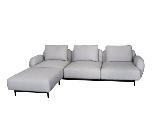 Lysegrå 3-personers sofa med chaiselong til højre, sorte ben, lave armlæn og rygpuder.
