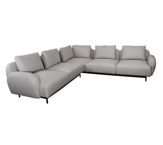 L-formet hjørnesofa i lys brun med lave armlæn og slanke sorte ben. Hynderne er bløde og fyldige.