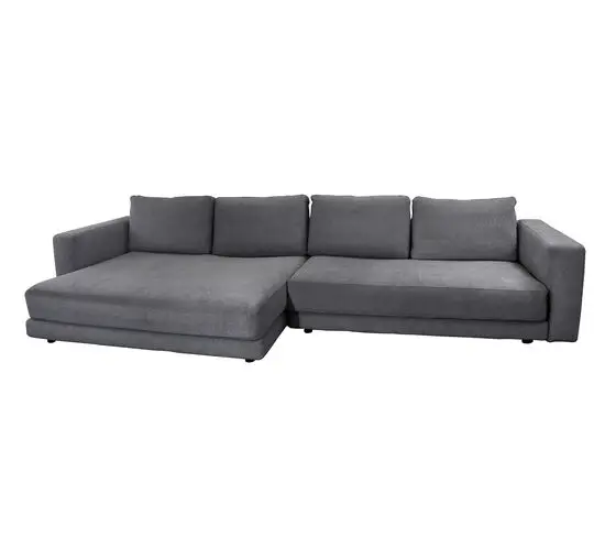 Mørkegrå L-formet sofa med dobbelt daybed, armlæn, tre ryghynder og to sædehynder.