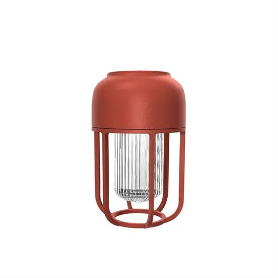 Rød, cylindrisk udendørslampe med solenergi. Kompakt design, stabil base til bærbar brug.