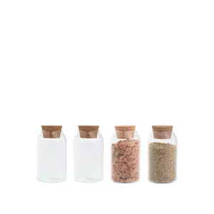 Fire cylindriske krydderikrukker, to fyldt med krydderier, to tomme, alle med korklåg.