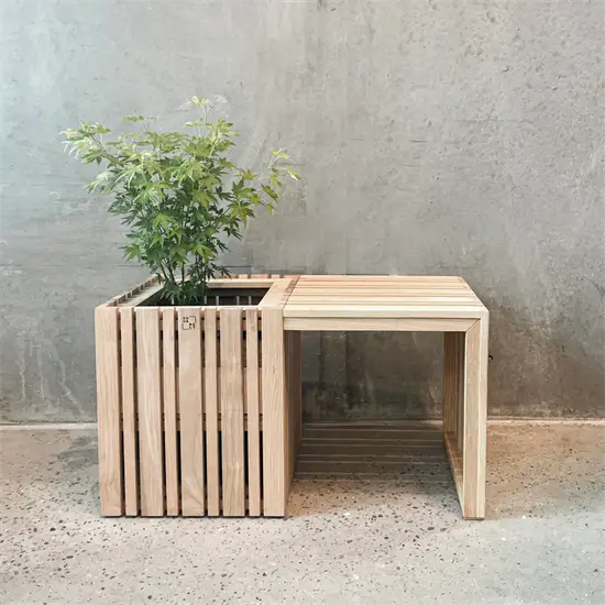 Træbord med indbygget plantekasse og grøn plante, minimalistisk design i naturlig asketræ.