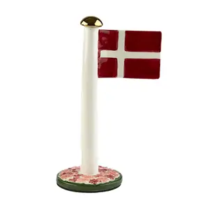 Dekorativ Dannebrog med rød baggrund, hvidt kors, hvid stang, guldkugle og blomsterbase.