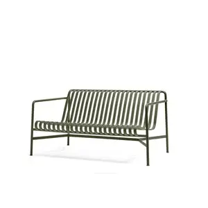 Minimalist grøn sofa med horisontale lameller og integrerede armlæn.