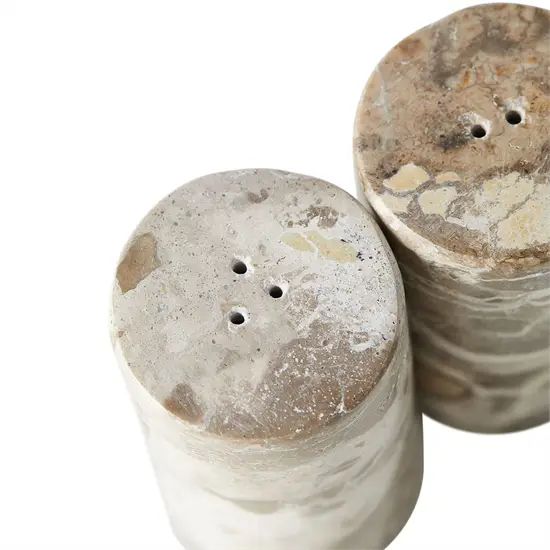 Salt- og pebersæt med cylindrisk form, mønstret overflade og huller i toppen til krydderier.