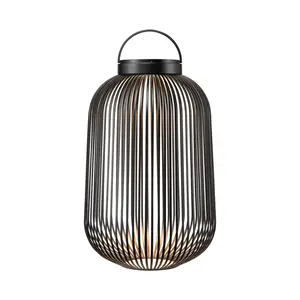 Sort, cylindrisk LED-lampe med lodrette stænger og bærbar hank. Lyset udsendes fra midten.
