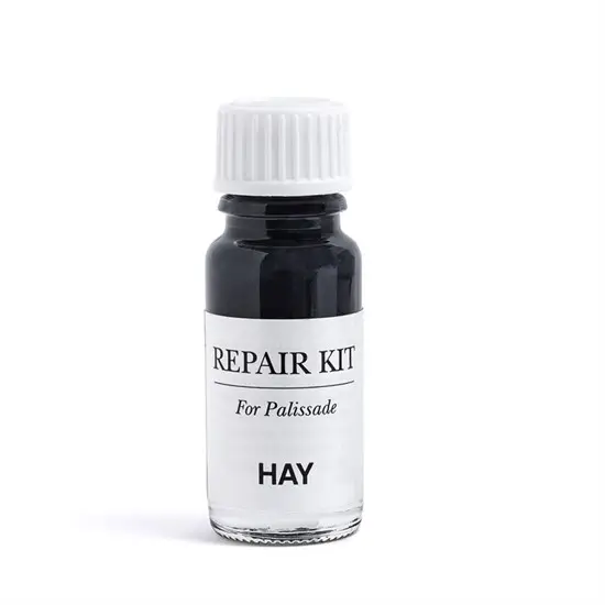 Lille flaske med mørk væske, mærket "REPAIR KIT For Palissade" fra HAY, med hvid skruelåg.