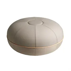 Rund pouf med knap-tuftet top og synlig omkreds-søm. Glat, tekstureret overflade i naturfarve.