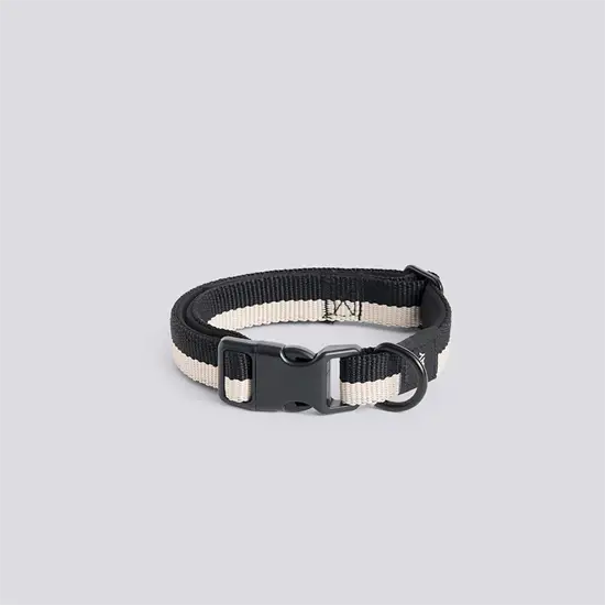 Hundehalsbånd med sort og hvidt design, flad form, plastikspænde og ring til snor.