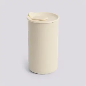 Beige termo-mug med fladt låg, cylindrisk design, og metallisk inderside.