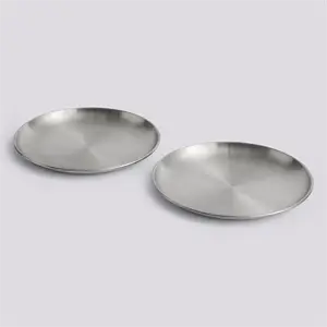 To store, runde tallerkener i børstet metal, velegnet til udendørs brug, ligger på en lys baggrund.