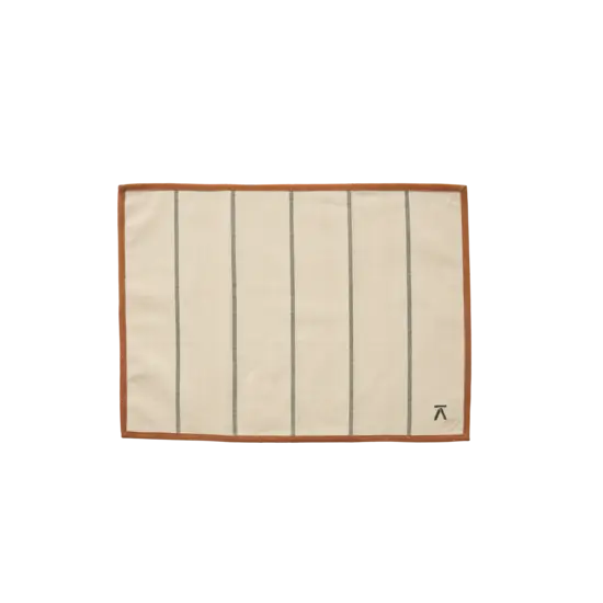 Grøn/brun dækkeserviet med lodrette linjer og brun kant. Logo nederst til højre.