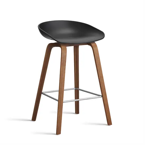 Sort barstol med plastiksæde, valnøddeben og metalfodstøtte. Lav model fra HAY.