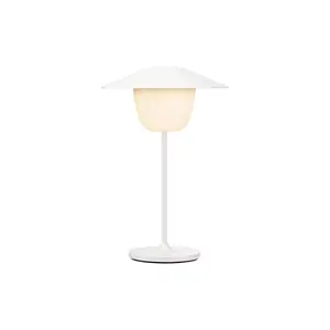 Minimalist hvid LED-lampe med bred top, slank stamme og cirkulær base.